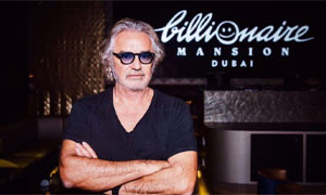 Flavio Briatore festeggia con una torta che elenca i successi dell'imprenditore